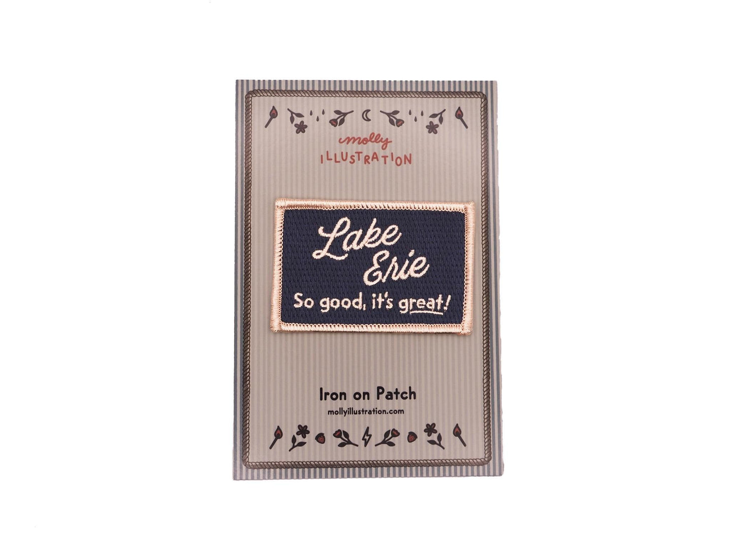 a blue rectangular embroidered iron on patch that reads "Lake Erie, So good, it's great!" in off white lettering packaged on a striped Molly Illustration backer card