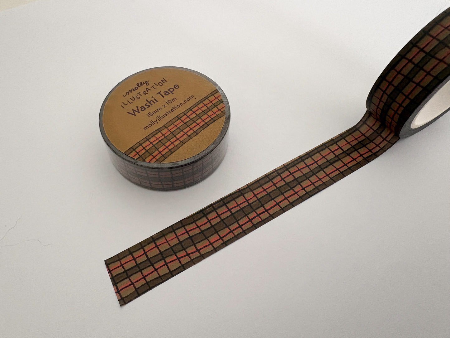 Roll of washi tape with a wonky plaid pattern on a white background