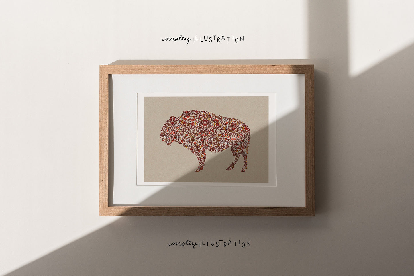 an illustrated art print of a multicolored floral illustrated buffalo silhouette over a tan background.