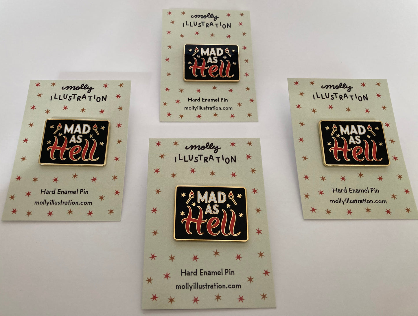 a group of vintage inspired illustrated hard enamel pins that read “Mad as Hell”