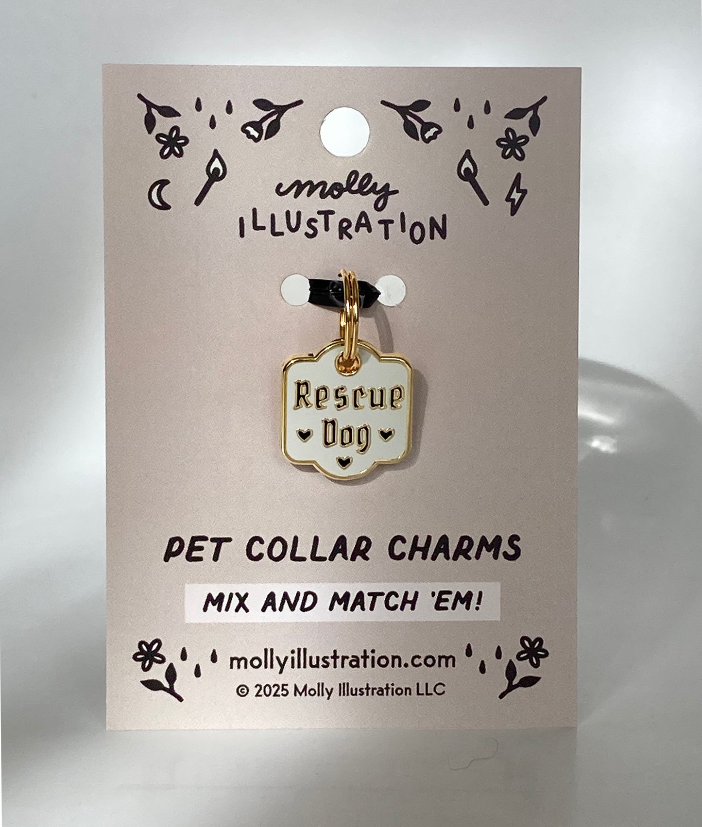 A hard enamel pet collar charm that reads “Rescue Dog”