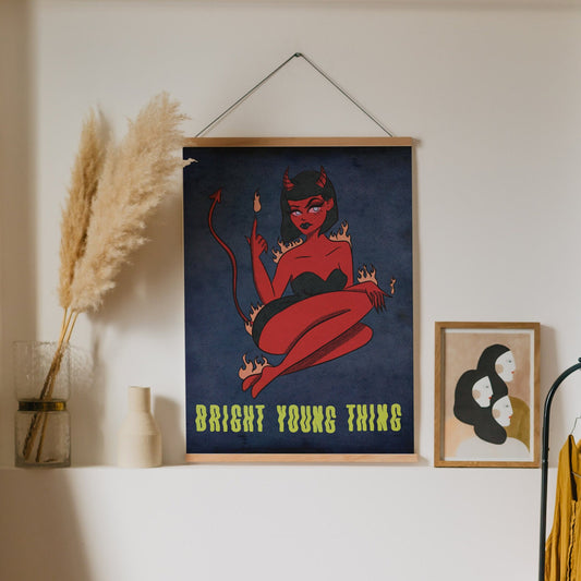 an illustrated art print of a cartoon devil pin up girl that is over a blue background and the text beneath it reads "bright young thing"