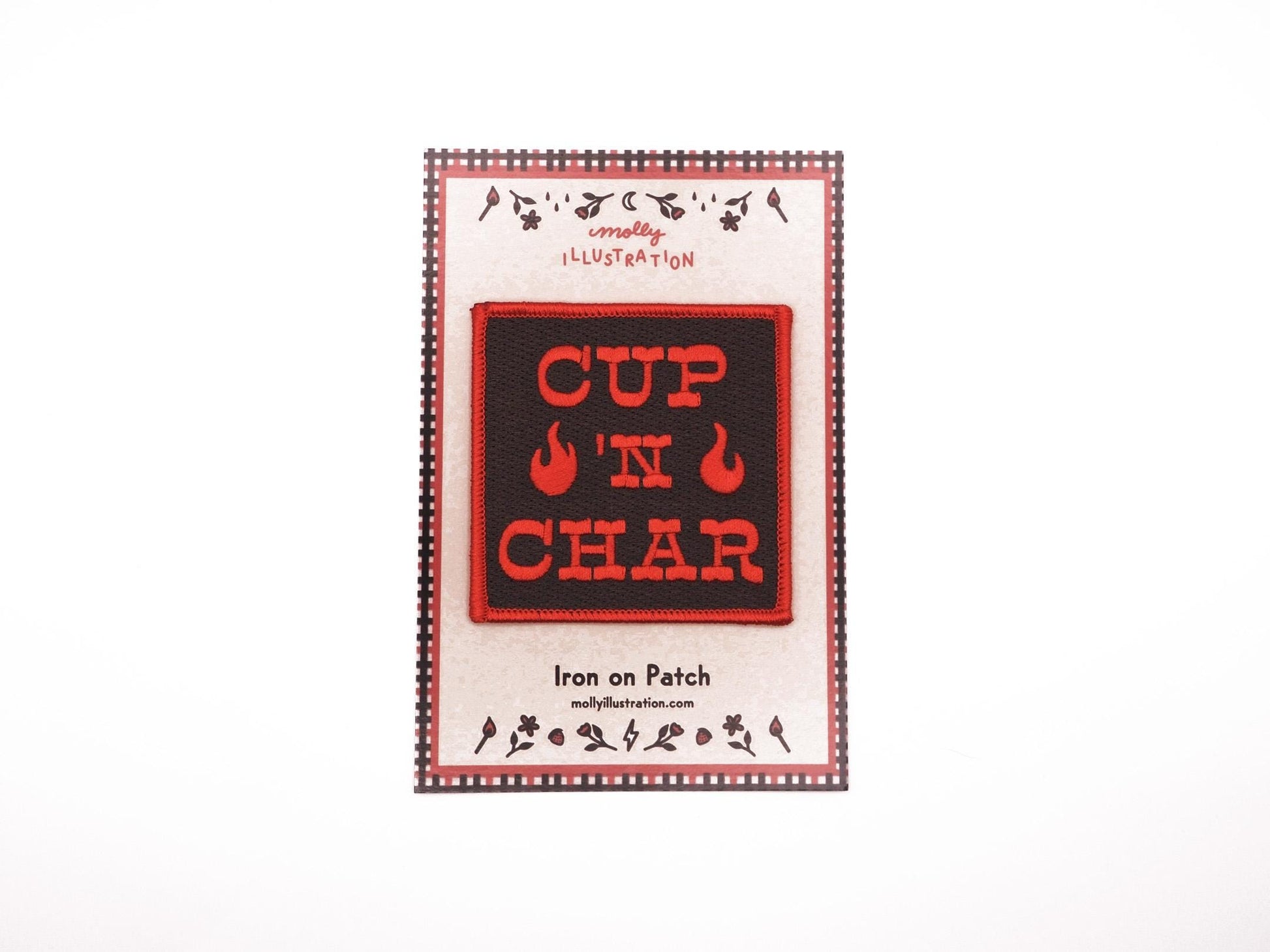 A black square embroidered iron on patch that reads "CUP 'N CHAR" in red letters. there are two red flames beside the "'N" and there is a red merrowed border. it is placed on top of a Molly Illustration backer card.