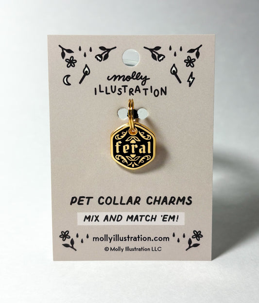 Black and gold pet collar charm that says "Feral" on a Molly Illustration backer card on a white back ground.