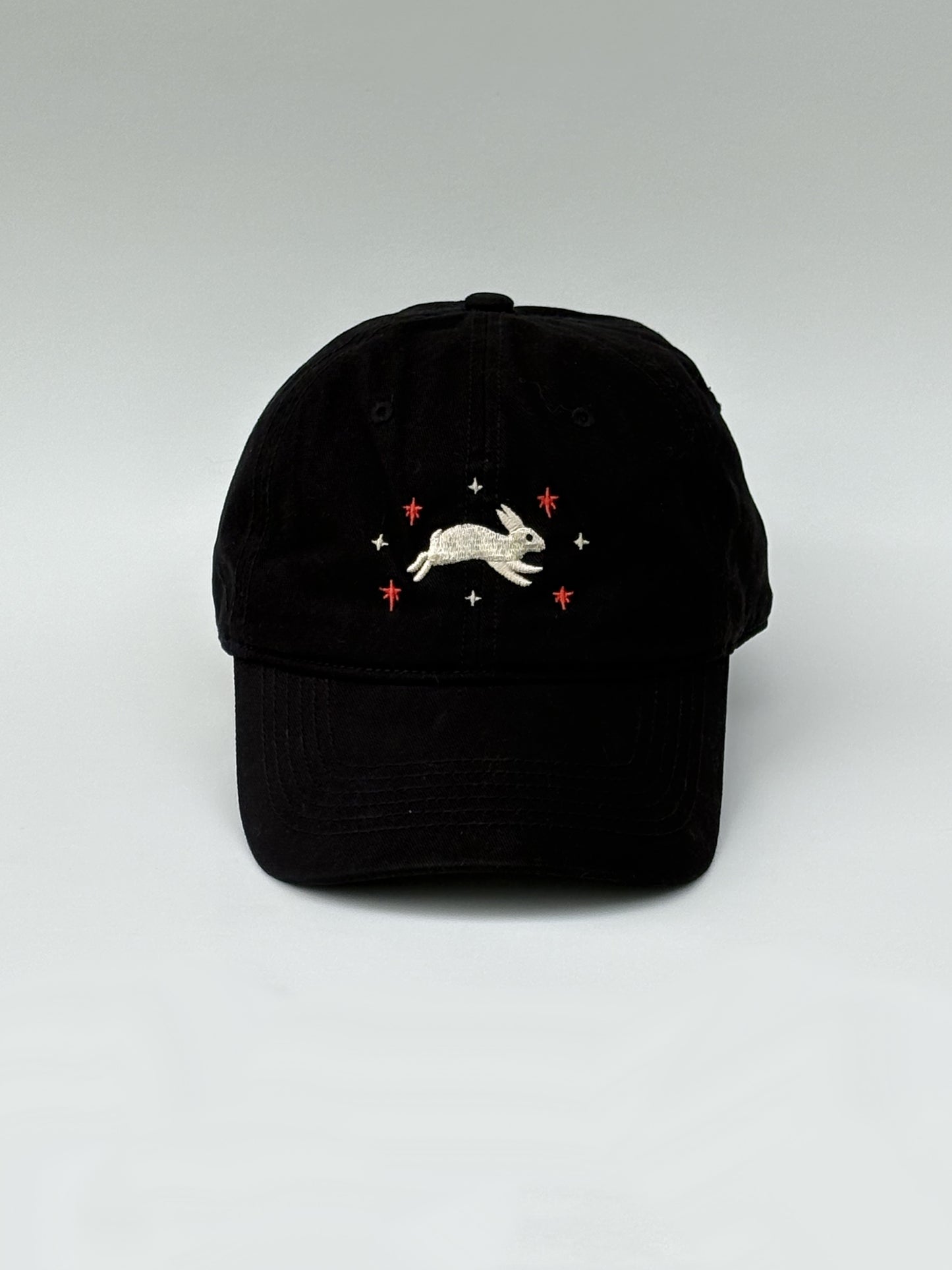Black cap with embroidered design on a white background