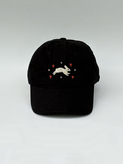 Black cap with embroidered design on a white background