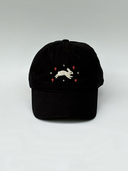 Black cap with embroidered design on a white background