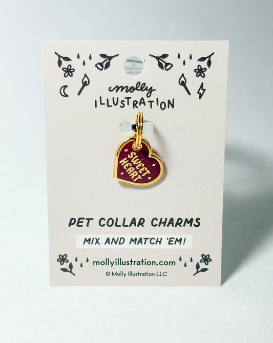 A burgundy and gold colored collar charm that reads "Sweet Heart"  on a Molly Illustration backer card 