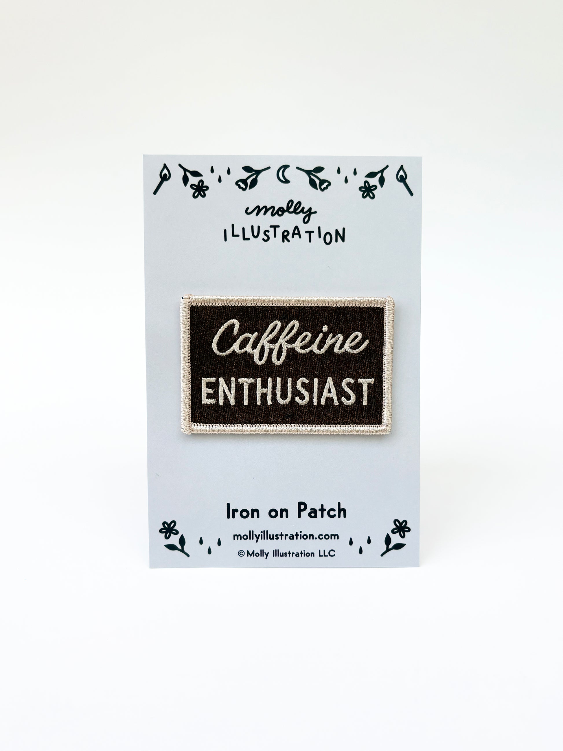 Iron on patch with 'Caffeine Enthusiast' text on a card with branding details.