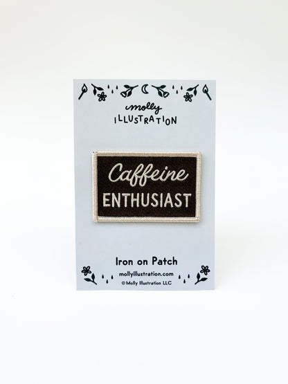 Iron on patch with 'Caffeine Enthusiast' text on a card with branding details.