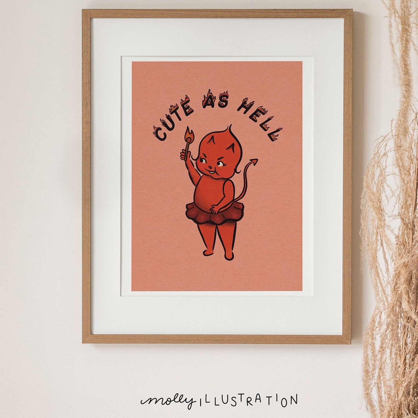 an illustrated art print of a cartoon red devil baby in a tutu lighting the phrase "cute as hell" on fire with a match