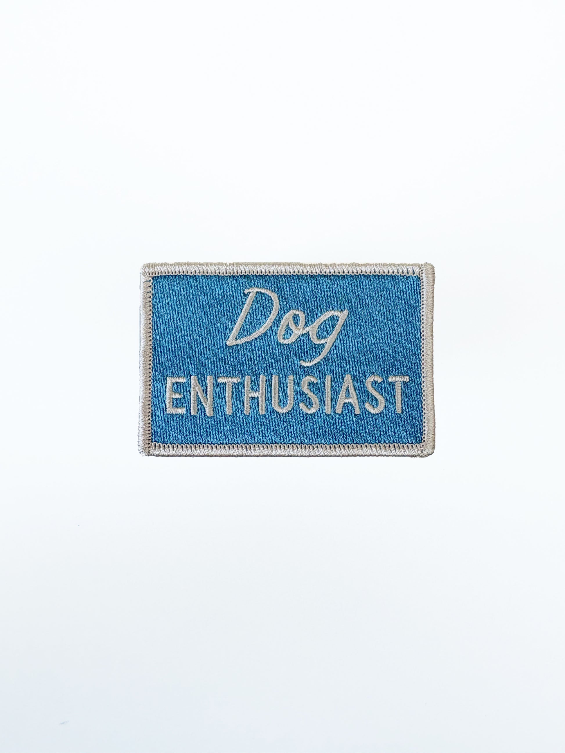 Embroidered patch with 'Dog Enthusiast' text on a blue background