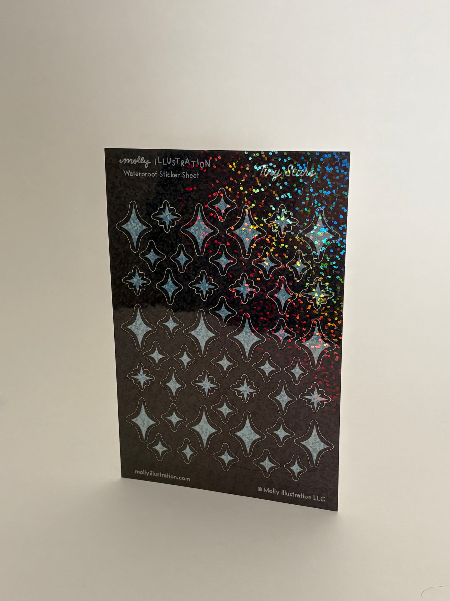 Sheet of star-patterned holographic stickers on a white background