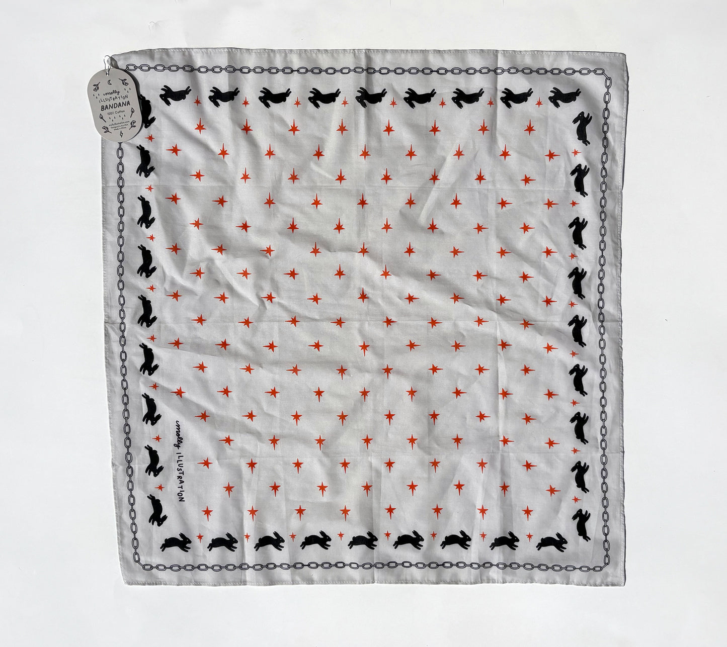 A square white scarf with a repeating pattern of small red stars, black rabbit silhouettes, and a black chain border, laid flat on a white background with a hanging tag.