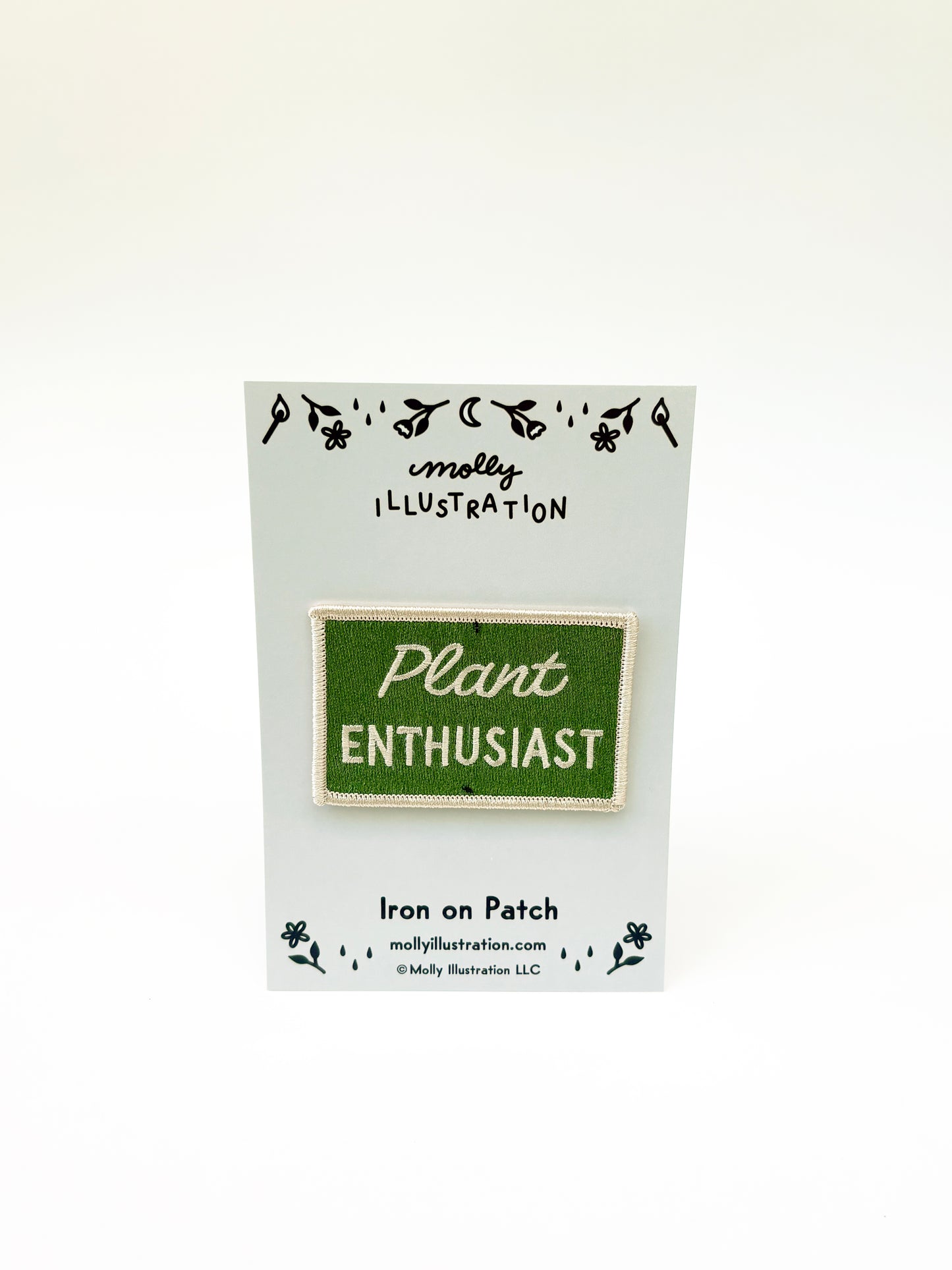 Iron on patch labeled 'Plant Enthusiast' by Molly Illustration on a white card.