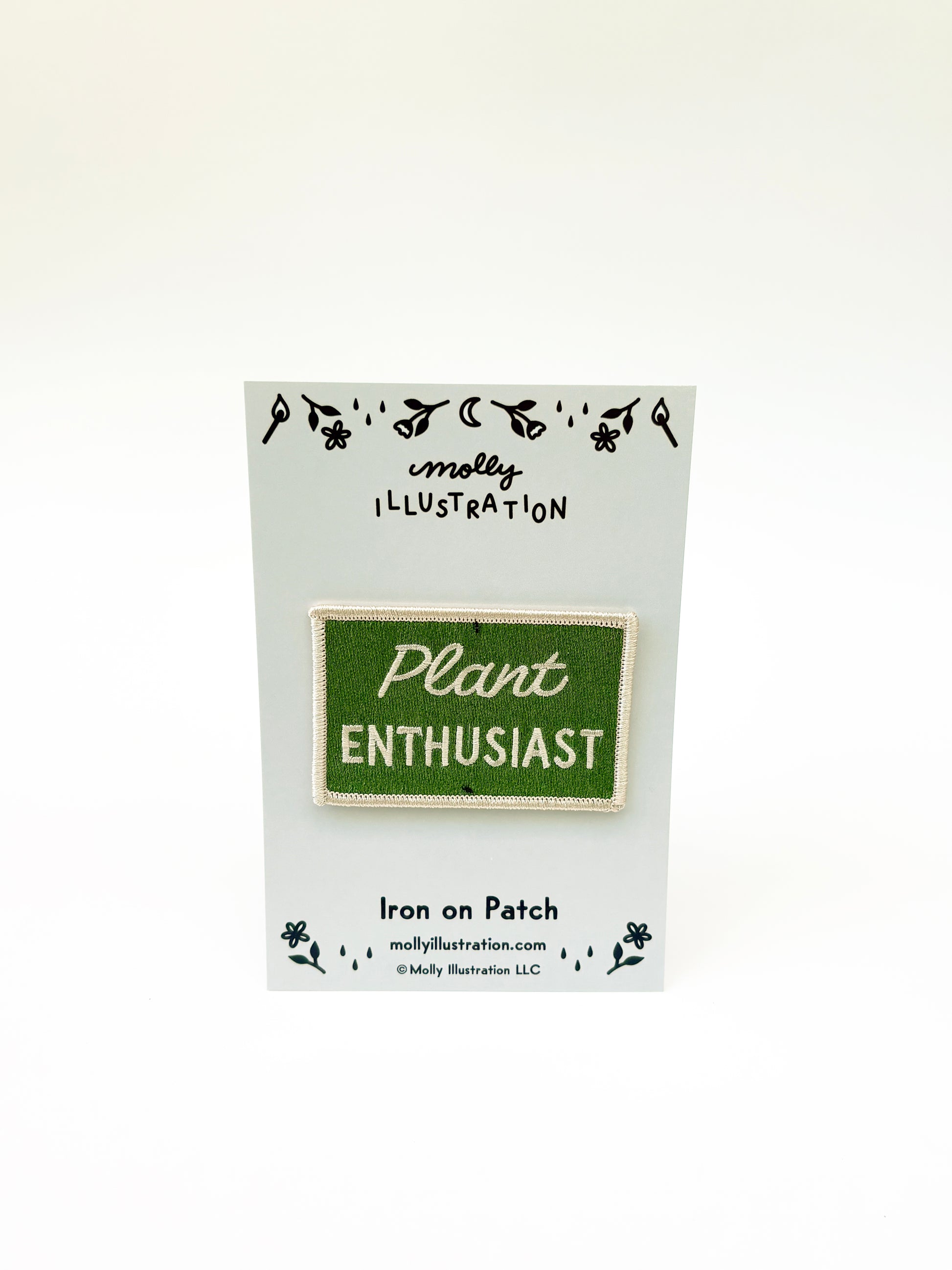 Iron on patch labeled 'Plant Enthusiast' by Molly Illustration on a white card.