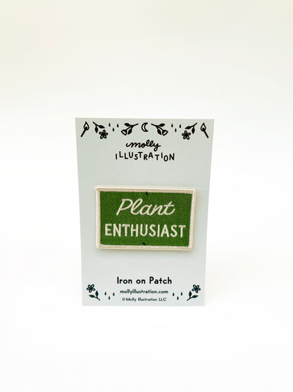 Iron on patch labeled 'Plant Enthusiast' by Molly Illustration on a white card.