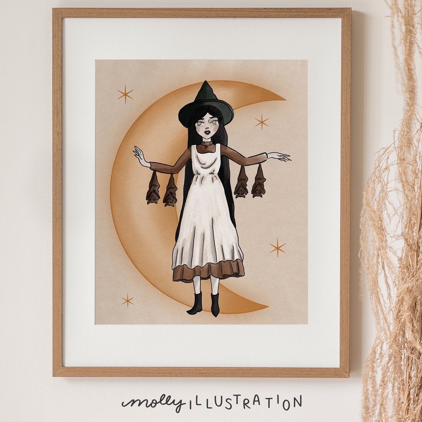 an art print of a cartoon witch with her arms out in front of a crescent moon while bats hang from her dress sleeves.