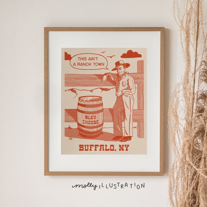 a vintage inspired illustrated art print of a cartoon cowboy beside a barrel of bleu cheese. The text beside it reads "this ain't a ranch town." and Buffalo, NY below it.