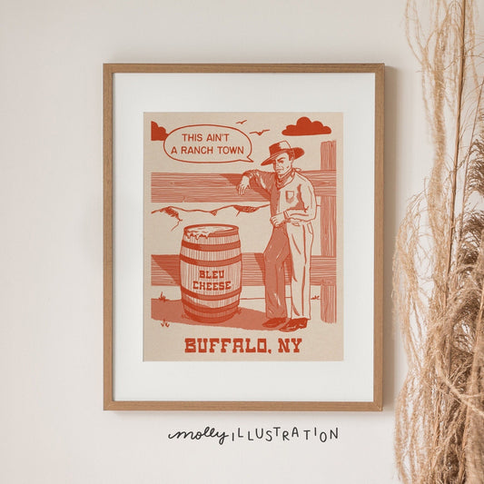 a vintage inspired illustrated art print of a cartoon cowboy beside a barrel of bleu cheese. The text beside it reads "this ain't a ranch town." and Buffalo, NY below it.