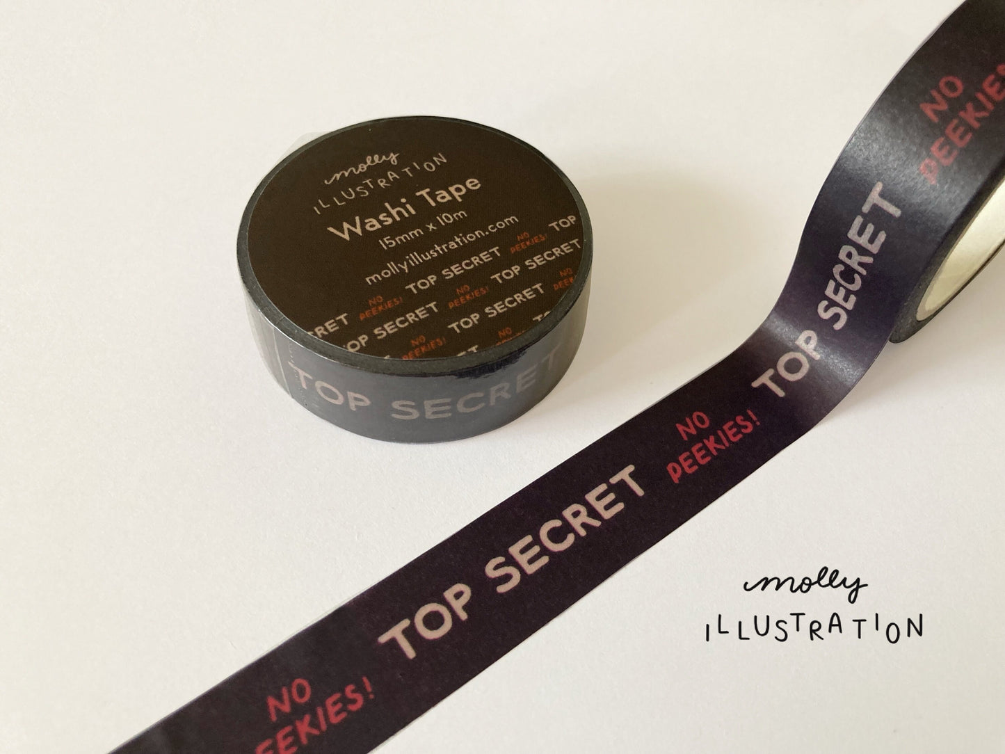 A roll of illustrated washi tape printed with the phrase “Top secret, No peekies!”