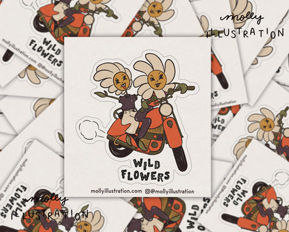 An illustrated kiss cut vinyl sticker of cartoon wildflowers on a motorcyle that reads "wild flowers."